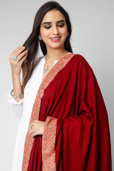 This bright maroon handmade Kashmiri pashmina shawl is made of the finest pashmina wool and has gorgeous Sozni embroidery done on all four sides in the conventional Dordaar pattern to wrap you in luxury. The shawl is enhanced by the delicate and exquisite needlework, which elevates its tradition.