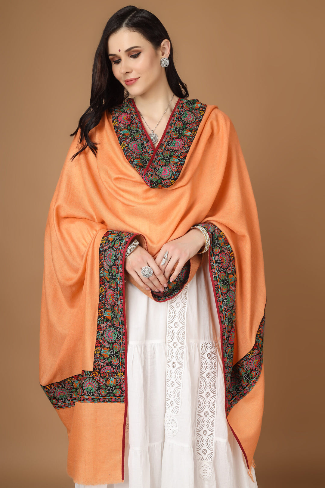 Kashmiri pashmina shawl, crafted from the finest pashmina and featuring elegant embroidery and a stunning peach-colored Dourdaar pattern. A thick Sozni patchwork embroidered border runs across the borders, showcasing exquisite designs made from multicolor Sozni threads entangled with each other.