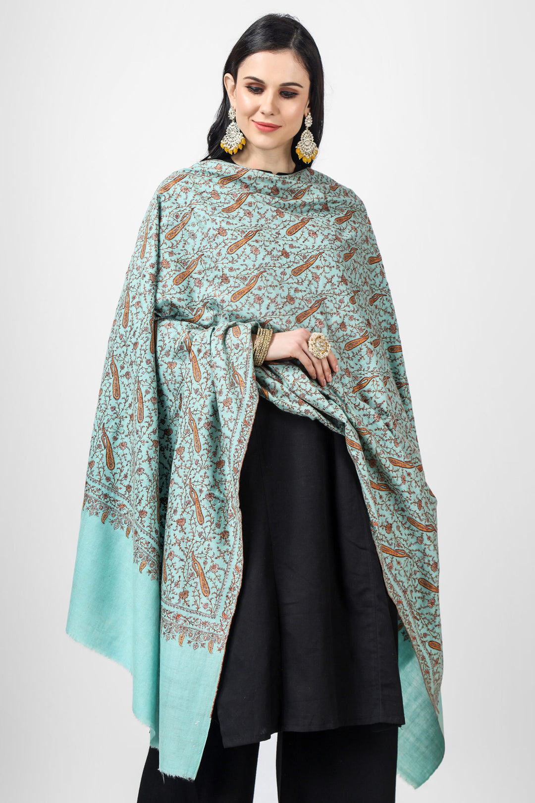 Indulge in luxury with this exquisite turquoise handmade Pashmina Shawl adorned with intricate Sozni embroidery in a Jaldaar pattern, crafted from the finest natural pashmina wool This shawl features charming Sozni silk threads in vivid floral vines that form symmetrical patterns,