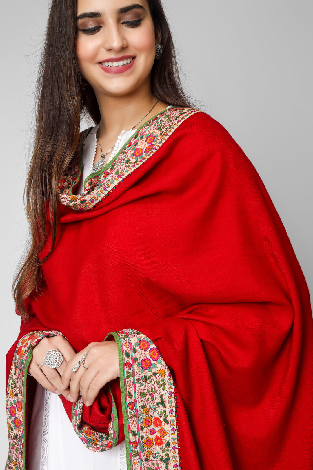 Kashmiri pashmina shawl, you may swaddle yourself in luxury. It was produced from the best pashmina wool and it has exquisite stitching and a lovely crimson Doordaar design. The borders are covered in a  Sozni patchwork embroidery border that displays beautiful designs created from tangled multicolor Sozni threads.