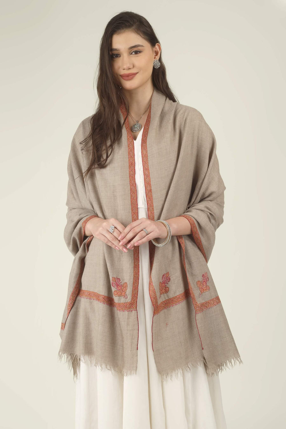 Front view of a natural Pashmina shawl with coral hand-embroidered border and paisley motifs
