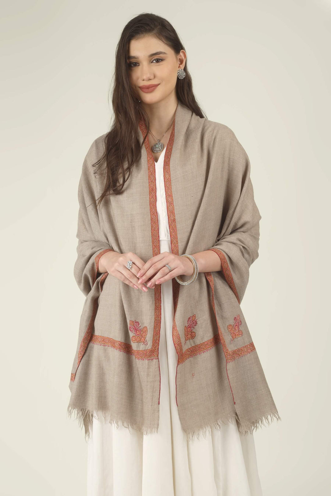Front view of a natural Pashmina shawl with coral hand-embroidered border and paisley motifs