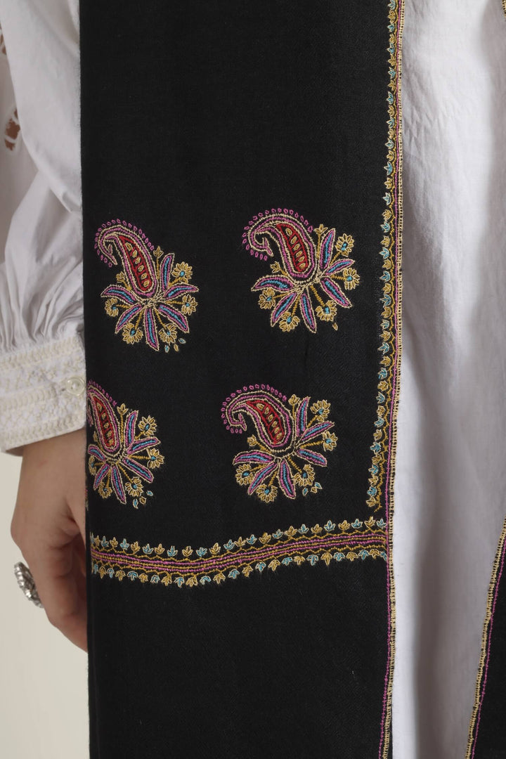 Model wearing a black GI Kashmiri Pure Pashmina stole with multicolour paisley Sozni embroidery on the borders over a white outfit.
    
      | pashmina shawls online | authentic Kashmiri pashmina shawl online | pure pashmina shawl online | original GI certified pashmina shawl online | luxury men's pashmina shawl online from Kashmir | where to buy online pure pashmina in India
    
    | GI Tag Certified - Government-verified authentic Kashmiri Pashmina
    | G20 Official Partner - Selected by India for G20 Summit gifting
    | Handicraft Registered - Official recognition of traditional craftsmanship
    | Certificate of Authenticity - Every purchase includes GI certification