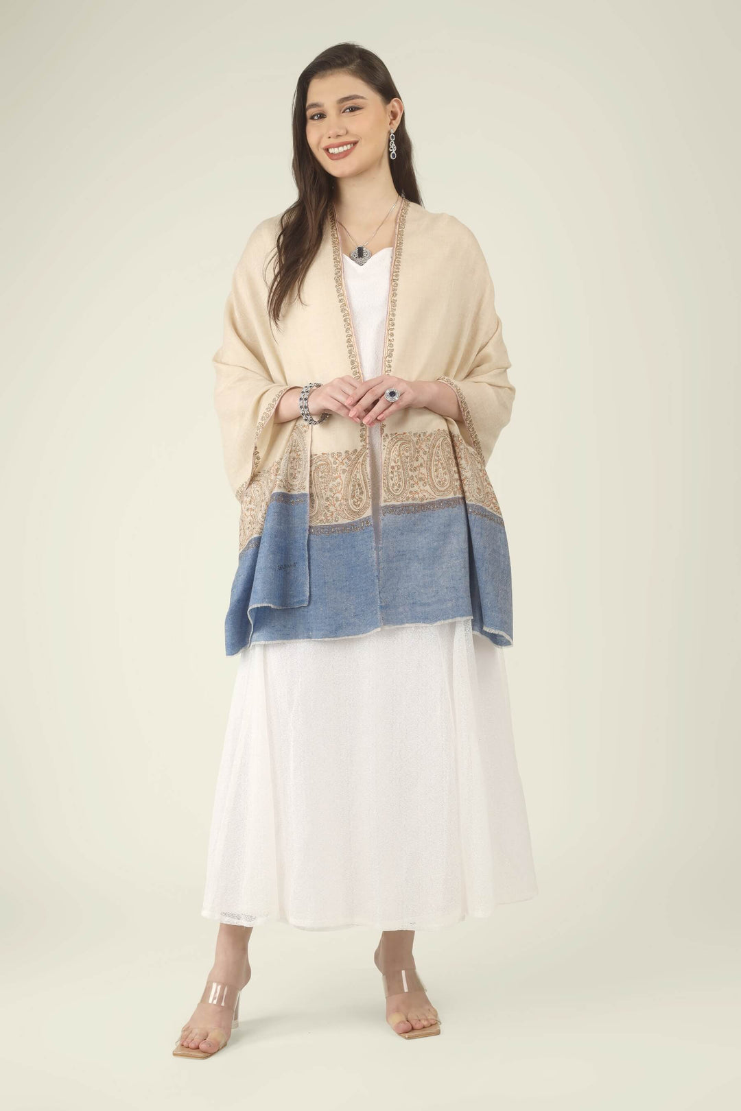 This Cream GI Kashmiri Pure Pashmina Paisley Embroidered Stole features a soft ivory-cream body with a richly worked paisley border and a contrasting panel of denim blue at the ends.