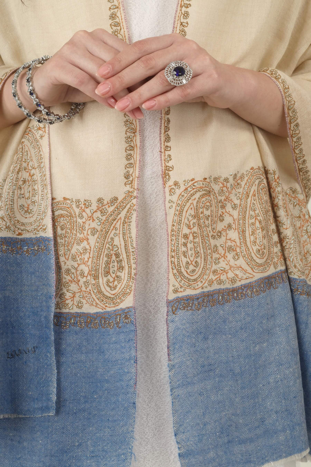This Cream GI Kashmiri Pure Pashmina Paisley Embroidered Stole features a soft ivory-cream body with a richly worked paisley border and a contrasting panel of denim blue at the ends.