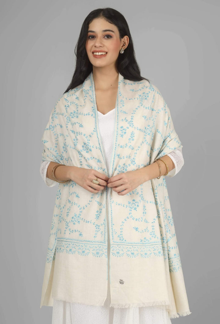 Close-up of a white GI Kashmiri Pure Pashmina stole with delicate sky-blue floral Sozni embroidery draped around the neck.
    
      | pashmina shawls online | authentic Kashmiri pashmina shawl online | pure pashmina shawl online | original GI certified pashmina shawl online | luxury men's pashmina shawl online from Kashmir | where to buy online pure pashmina in India
    
    | GI Tag Certified - Government-verified authentic Kashmiri Pashmina
    | G20 Official Partner - Selected by India for G20 Summit gifting
    | Handicraft Registered - Official recognition of traditional craftsmanship
    | Certificate of Authenticity - Every purchase includes GI certification