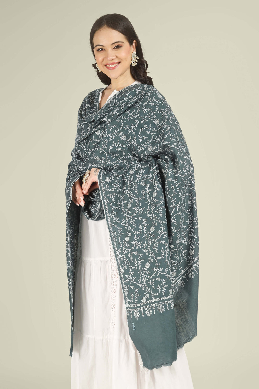 This Charcoal GI Kashmiri Pure Pashmina Javeria Jaldaar Shawl features a deep charcoal-grey base overlaid with a soft beige jaldaar sozni pattern, where fine creepers and flowers form a light mesh across the upper field and flow into a scalloped floral border.