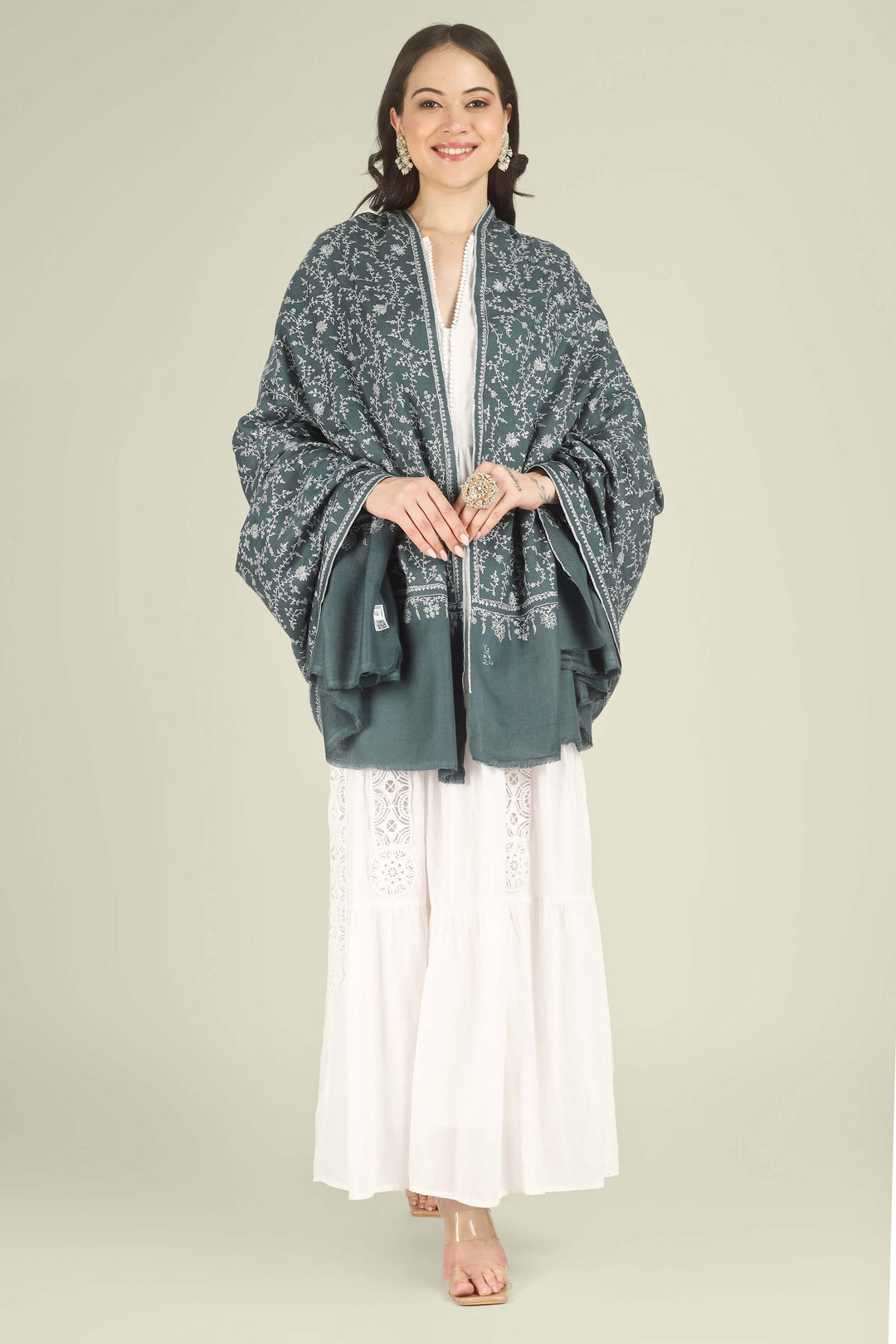 This Charcoal GI Kashmiri Pure Pashmina Javeria Jaldaar Shawl features a deep charcoal-grey base overlaid with a soft beige jaldaar sozni pattern, where fine creepers and flowers form a light mesh across the upper field and flow into a scalloped floral border.