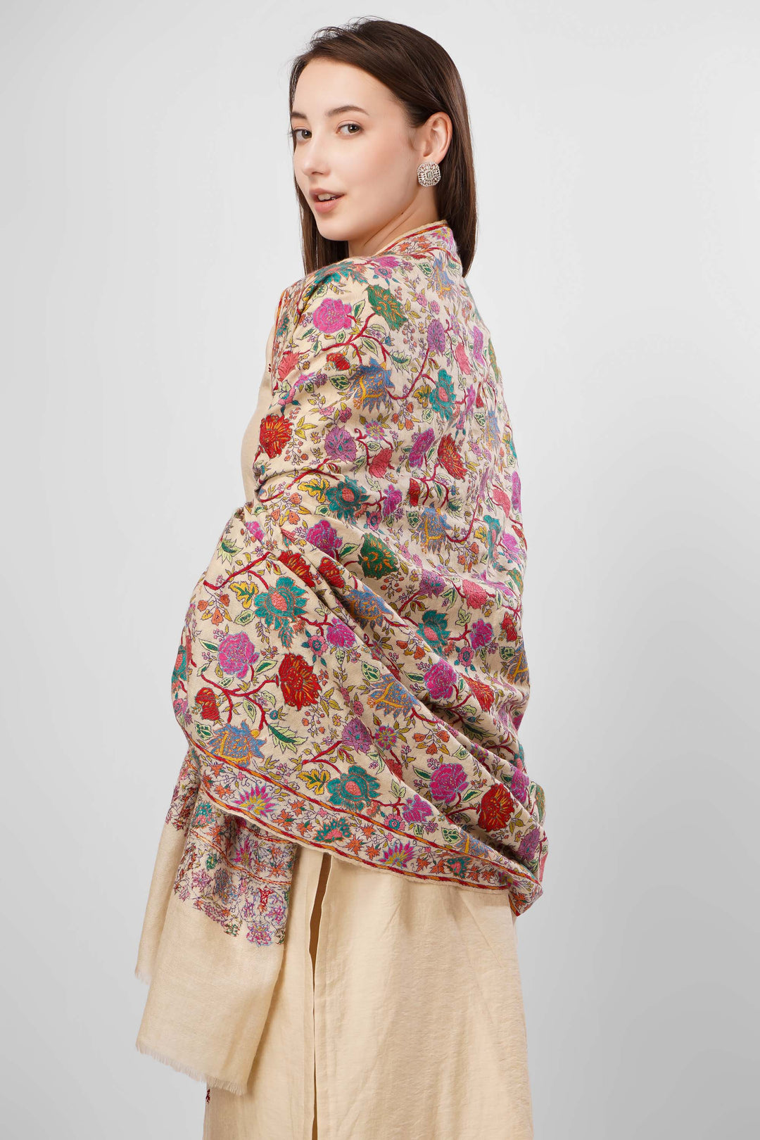 White Sozni Jama Pashmina Shawls Online – Artistry in Multicolor Floral Finesse
   The Pashmina White Sozni Malaika Ruqaiya Jama Shawl is a dazzling instance of Kashmiri handwoven royalty. Spun from premium pure pashmina, this shawl features a pristine ivory-white base enveloped in flamboyant allover sozni embroidery