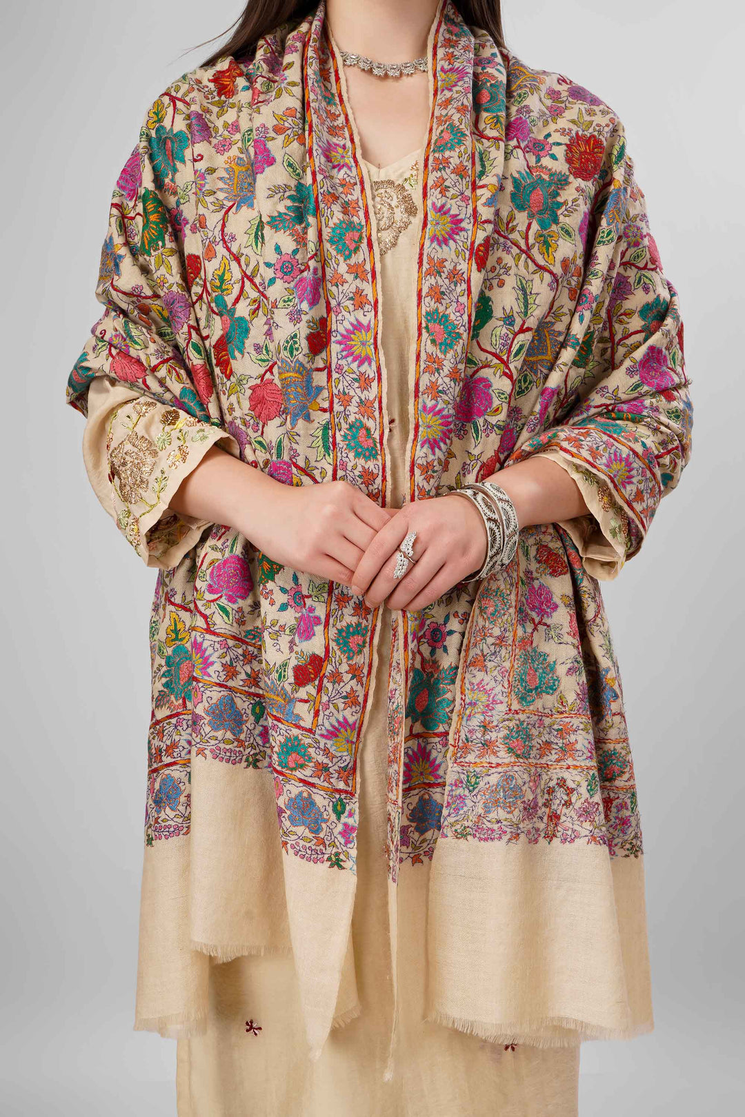 White Sozni Jama Pashmina Shawls Online – Artistry in Multicolor Floral Finesse
   The Pashmina White Sozni Malaika Ruqaiya Jama Shawl is a dazzling instance of Kashmiri handwoven royalty. Spun from premium pure pashmina, this shawl features a pristine ivory-white base enveloped in flamboyant allover sozni embroidery