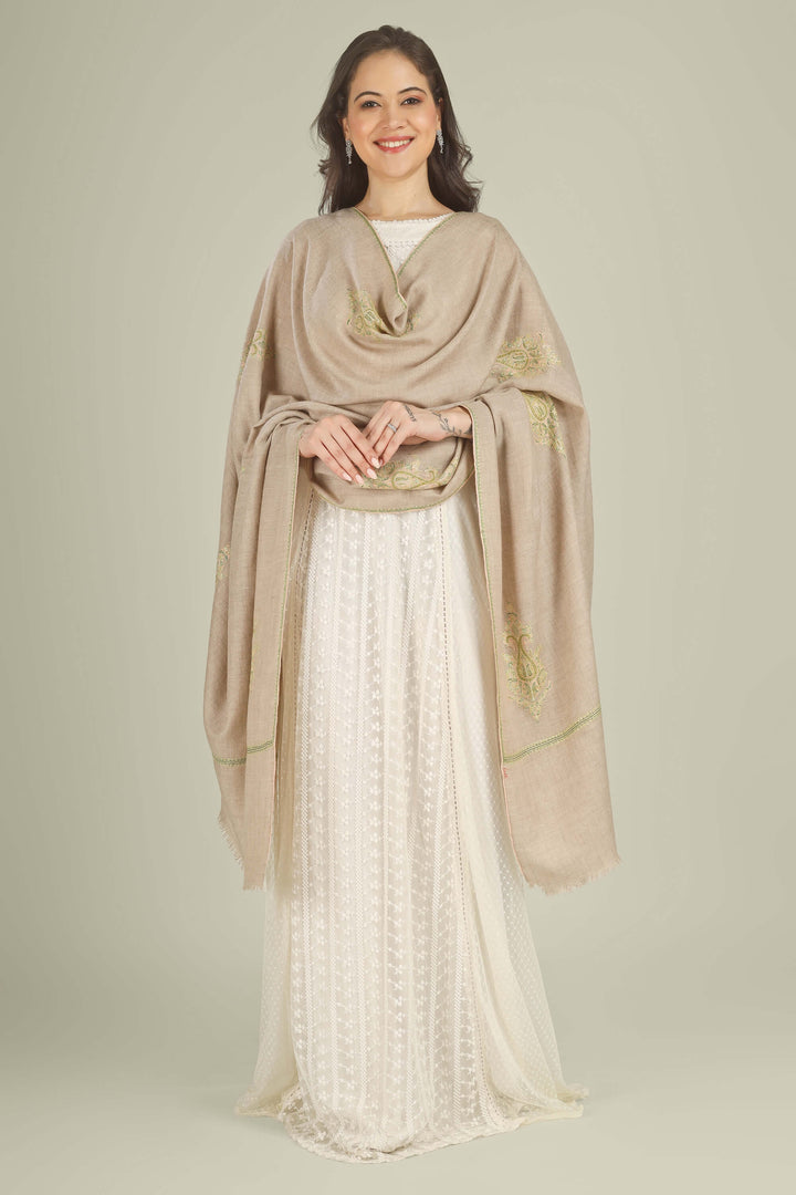 A woman modeling a draped beige shawl with gold embroidery over a white embroidered dress against a solid light beige studio background.
    
      | pashmina shawls online | authentic Kashmiri pashmina shawl online | pure pashmina shawl online | original GI certified pashmina shawl online | luxury men's pashmina shawl online from Kashmir | where to buy online pure pashmina in India
    
    | GI Tag Certified - Government-verified authentic Kashmiri Pashmina
    | G20 Official Partner - Selected by India for G20 Summit gifting
    | Handicraft Registered - Official recognition of traditional craftsmanship
    | Certificate of Authenticity - Every purchase includes GI certification