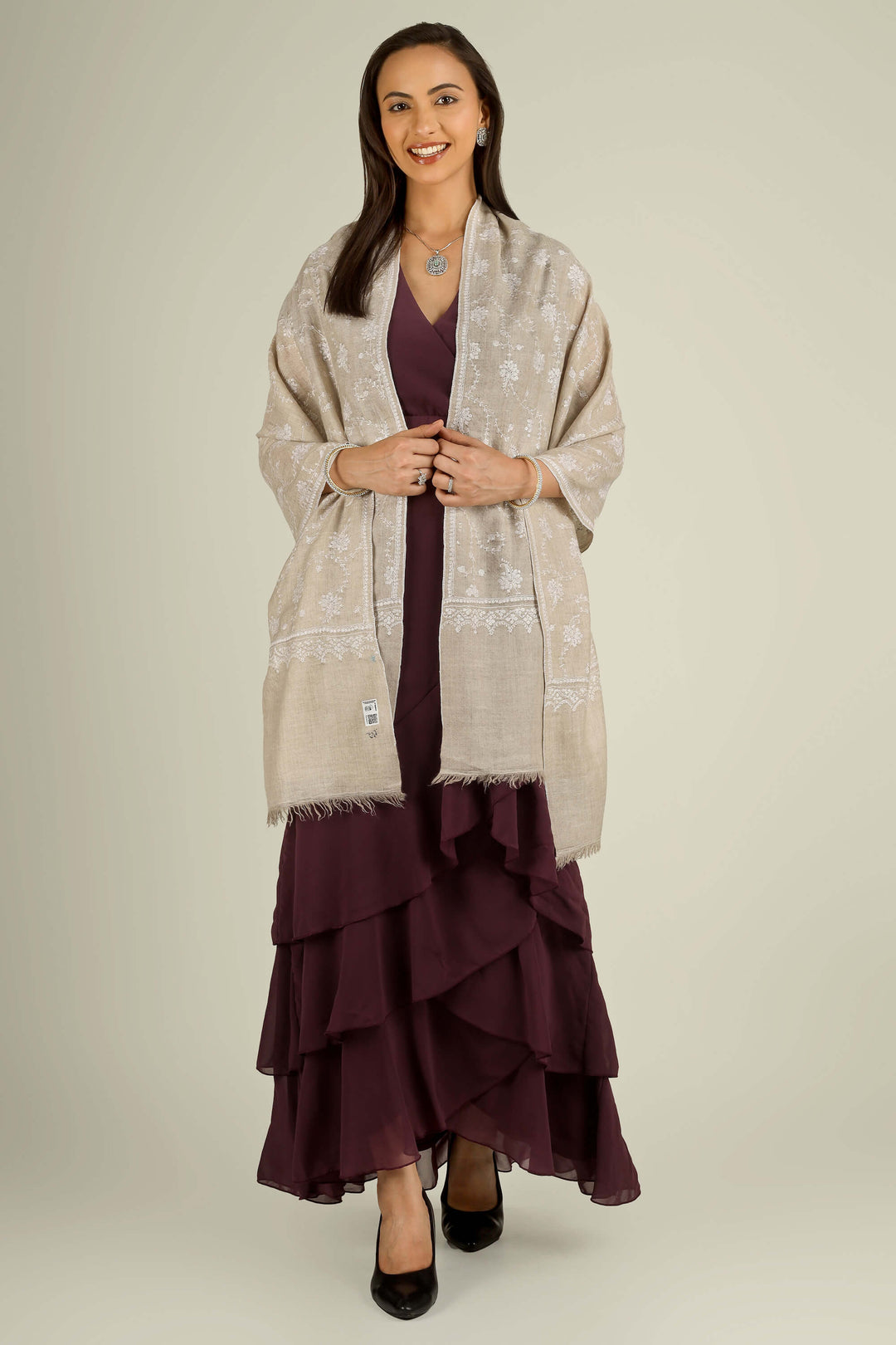 Beige GI Kashmiri pure pashmina embroidered stole by Kepra, draped on smiling model over plum dress, front view for Vienna winter styling