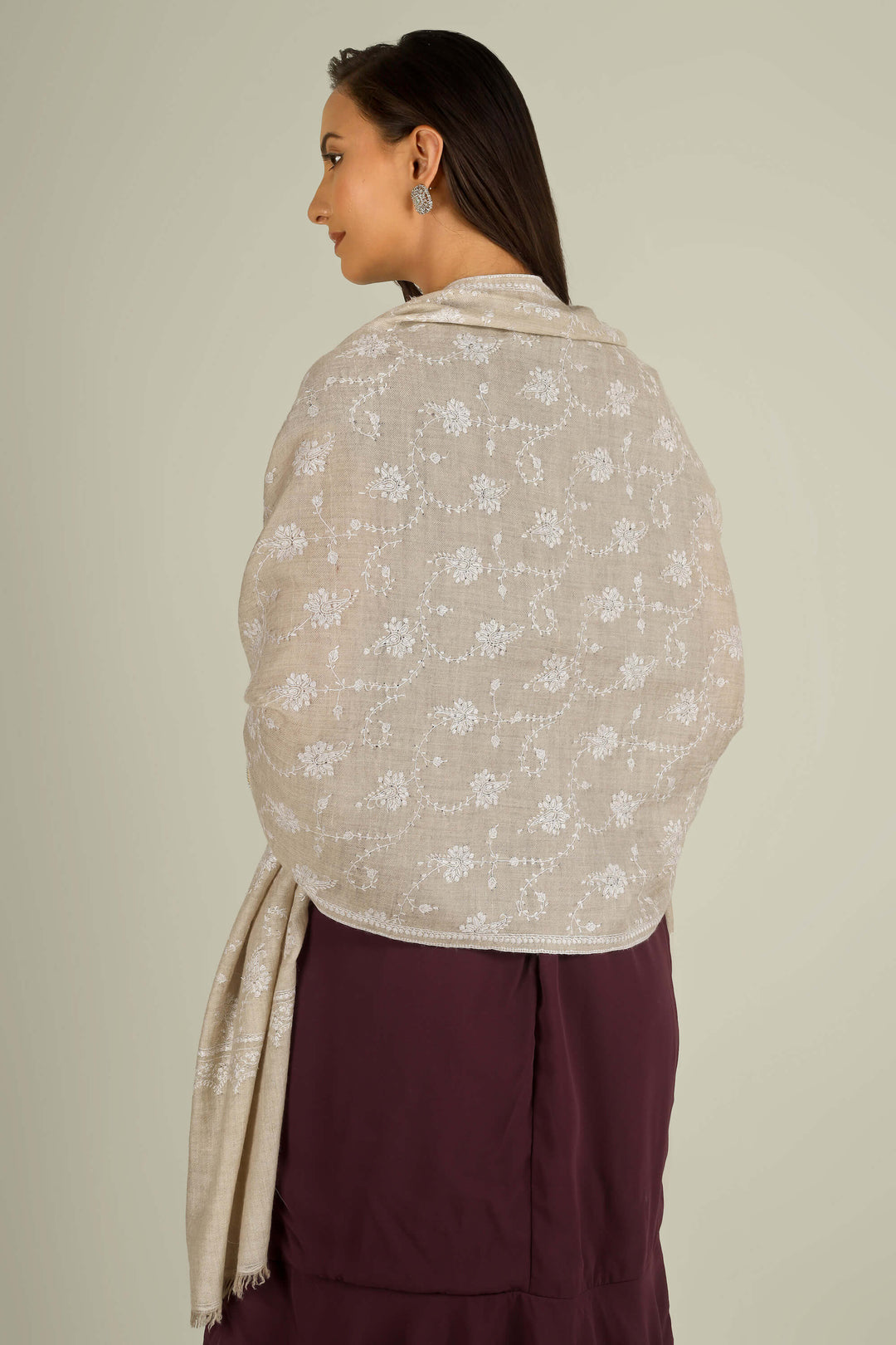 Beige GI Kashmiri pure pashmina embroidered stole by Kepra, draped on smiling model over plum dress, front view for Vienna winter styling