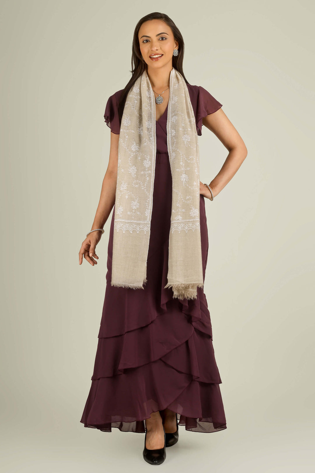 Beige GI Kashmiri pure pashmina embroidered stole by Kepra, draped on smiling model over plum dress, front view for Vienna winter styling