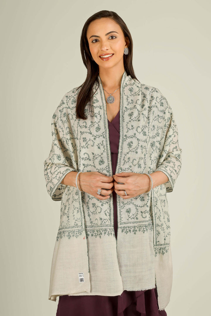 Ivory Kashmiri pure pashmina embroidered stole with green vine motifs by Kepra, wrapped around neck over plum dress, front detail view for Barcelona winter styling
    
      | pashmina shawls online | authentic Kashmiri pashmina shawl online | pure pashmina shawl online | original GI certified pashmina shawl online | luxury men's pashmina shawl online from Kashmir | where to buy online pure pashmina in India
    
    | GI Tag Certified - Government-verified authentic Kashmiri Pashmina
    | G20 Official Partner - Selected by India for G20 Summit gifting
    | Handicraft Registered - Official recognition of traditional craftsmanship
    | Certificate of Authenticity - Every purchase includes GI certification