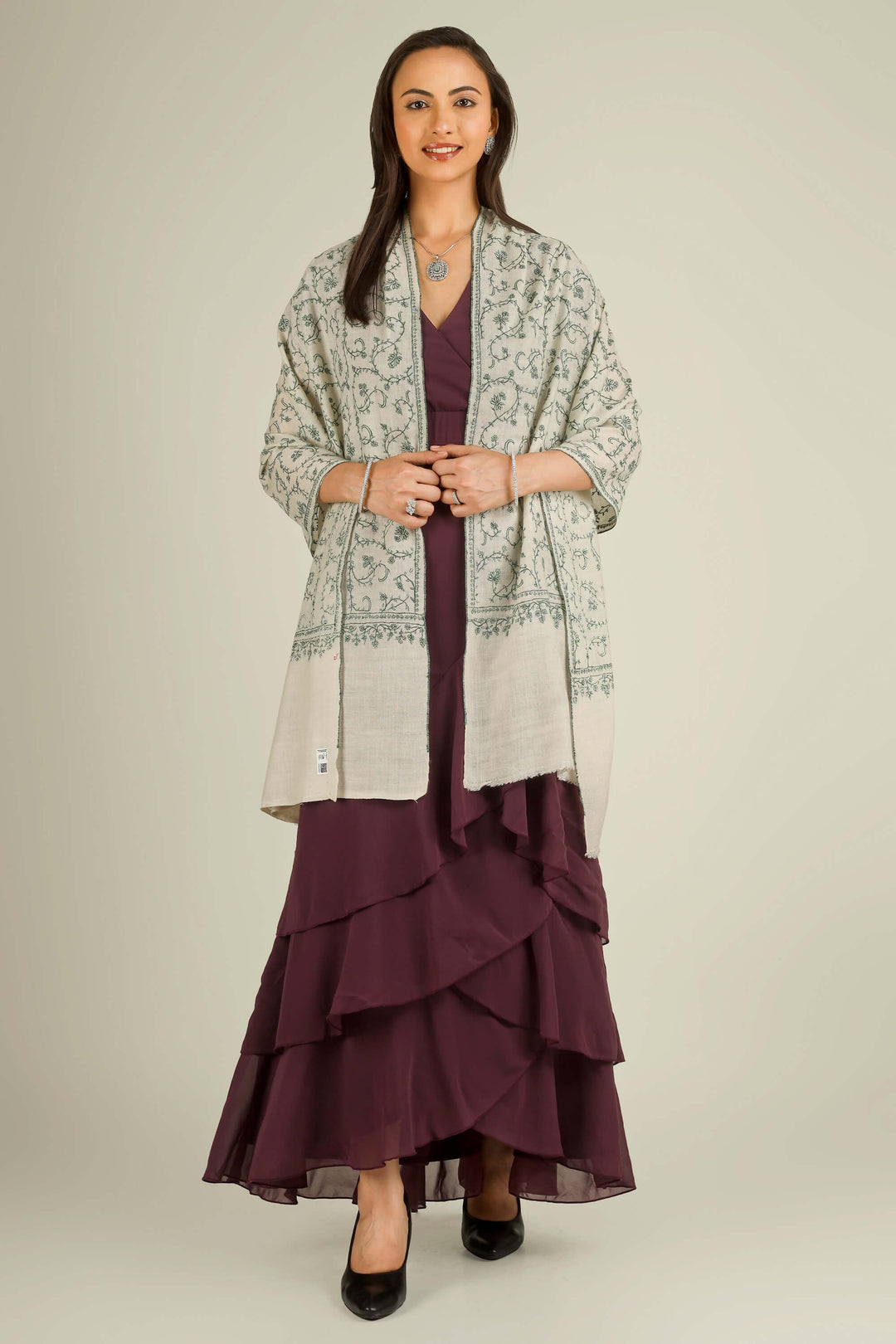 Ivory Kashmiri pure pashmina embroidered stole with green vine motifs by Kepra, wrapped around neck over plum dress, front detail view for Barcelona winter styling