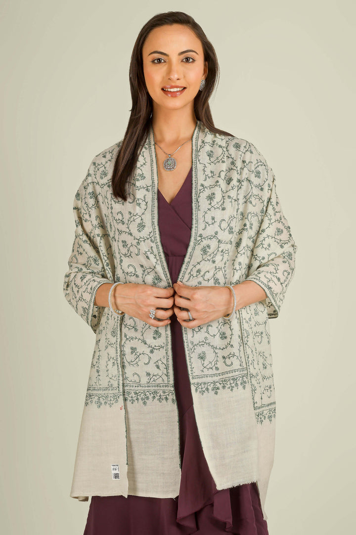 Ivory Kashmiri pure pashmina embroidered stole with green vine motifs by Kepra, wrapped around neck over plum dress, front detail view for Barcelona winter styling
    
      | pashmina shawls online | authentic Kashmiri pashmina shawl online | pure pashmina shawl online | original GI certified pashmina shawl online | luxury men's pashmina shawl online from Kashmir | where to buy online pure pashmina in India
    
    | GI Tag Certified - Government-verified authentic Kashmiri Pashmina
    | G20 Official Partner - Selected by India for G20 Summit gifting
    | Handicraft Registered - Official recognition of traditional craftsmanship
    | Certificate of Authenticity - Every purchase includes GI certification