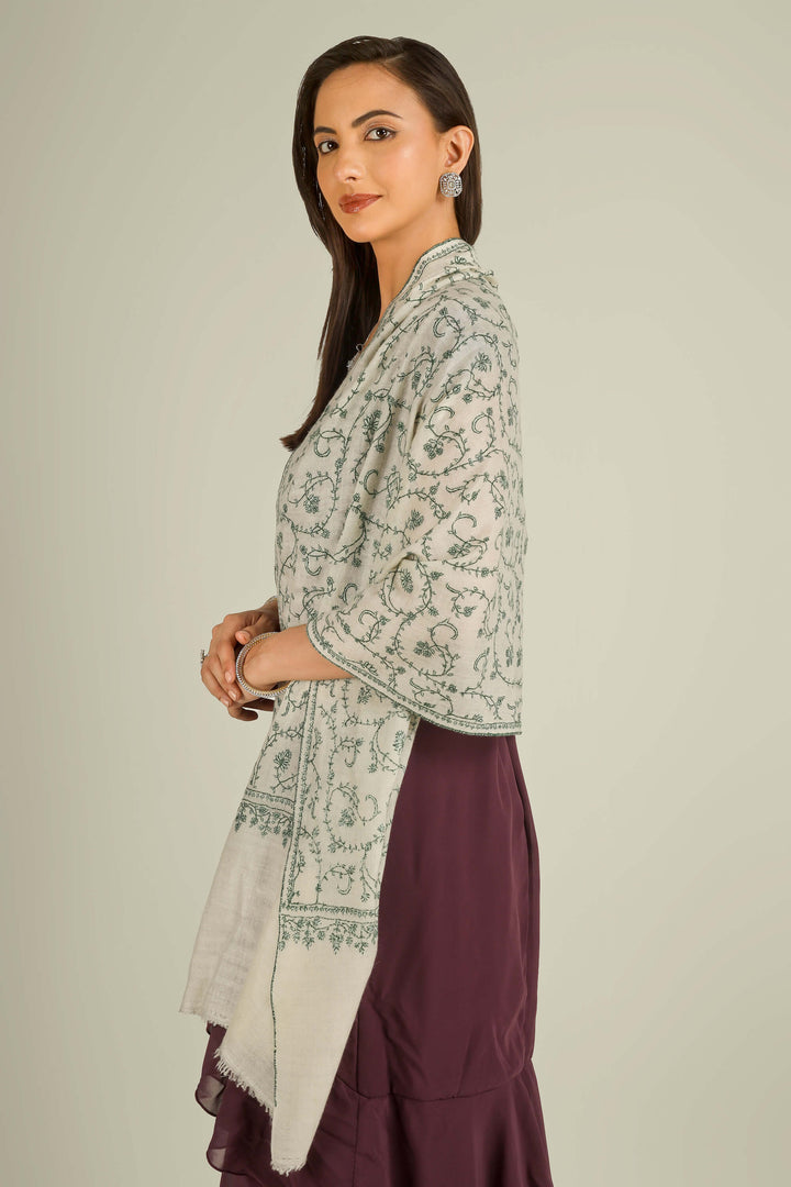Ivory Kashmiri pure pashmina embroidered stole with green vine motifs by Kepra, wrapped around neck over plum dress, front detail view for Barcelona winter styling
    
      | pashmina shawls online | authentic Kashmiri pashmina shawl online | pure pashmina shawl online | original GI certified pashmina shawl online | luxury men's pashmina shawl online from Kashmir | where to buy online pure pashmina in India
    
    | GI Tag Certified - Government-verified authentic Kashmiri Pashmina
    | G20 Official Partner - Selected by India for G20 Summit gifting
    | Handicraft Registered - Official recognition of traditional craftsmanship
    | Certificate of Authenticity - Every purchase includes GI certification
