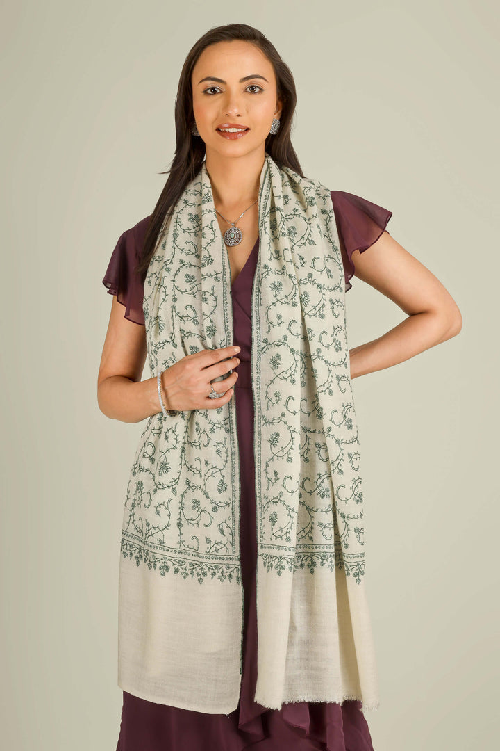 Ivory Kashmiri pure pashmina embroidered stole with green vine motifs by Kepra, wrapped around neck over plum dress, front detail view for Barcelona winter styling
    
      | pashmina shawls online | authentic Kashmiri pashmina shawl online | pure pashmina shawl online | original GI certified pashmina shawl online | luxury men's pashmina shawl online from Kashmir | where to buy online pure pashmina in India
    
    | GI Tag Certified - Government-verified authentic Kashmiri Pashmina
    | G20 Official Partner - Selected by India for G20 Summit gifting
    | Handicraft Registered - Official recognition of traditional craftsmanship
    | Certificate of Authenticity - Every purchase includes GI certification