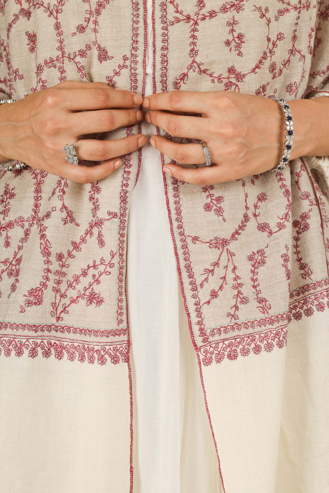 Close-up of beige Kashmiri pure pashmina stole with red sozni vine embroidery, held at the front, detail view for Berlin winter styling