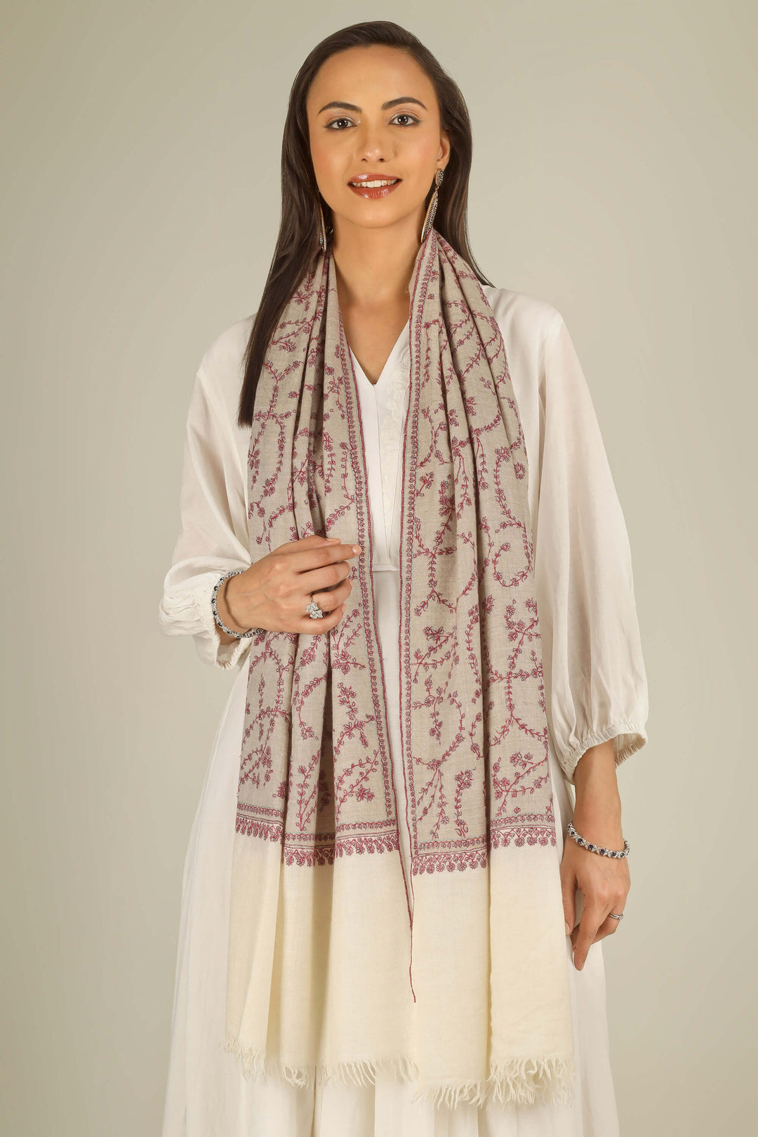 Close-up of beige Kashmiri pure pashmina stole with red sozni vine embroidery, held at the front, detail view for Berlin winter styling