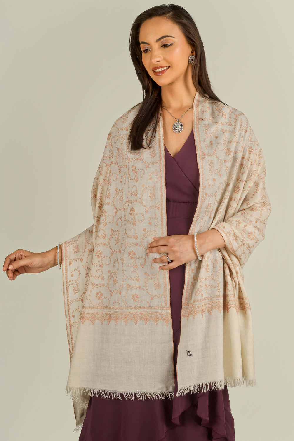 Close-up of beige Kashmiri pure pashmina sozni embroidered stole with red vines, held at the front, detail view for Amsterdam winter styling