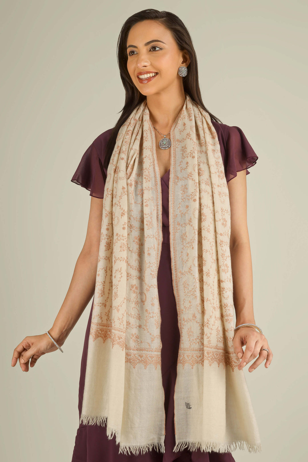 Close-up of beige Kashmiri pure pashmina sozni embroidered stole with red vines, held at the front, detail view for Amsterdam winter styling