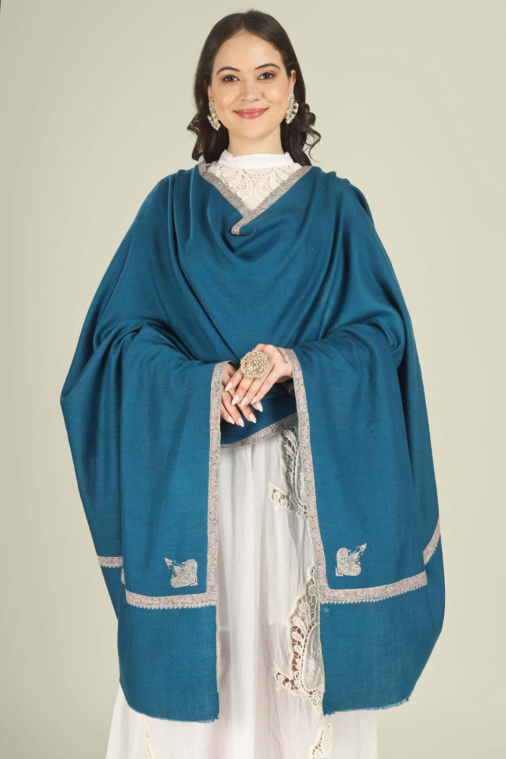 A woman modeling a teal blue shawl with silver embroidered borders and tassels, draped over a white traditional outfit against a solid light beige background.
    
      | pashmina shawls online | authentic Kashmiri pashmina shawl online | pure pashmina shawl online | original GI certified pashmina shawl online | luxury men's pashmina shawl online from Kashmir | where to buy online pure pashmina in India
    
    | GI Tag Certified - Government-verified authentic Kashmiri Pashmina
    | G20 Official Partner - Selected by India for G20 Summit gifting
    | Handicraft Registered - Official recognition of traditional craftsmanship
    | Certificate of Authenticity - Every purchase includes GI certification