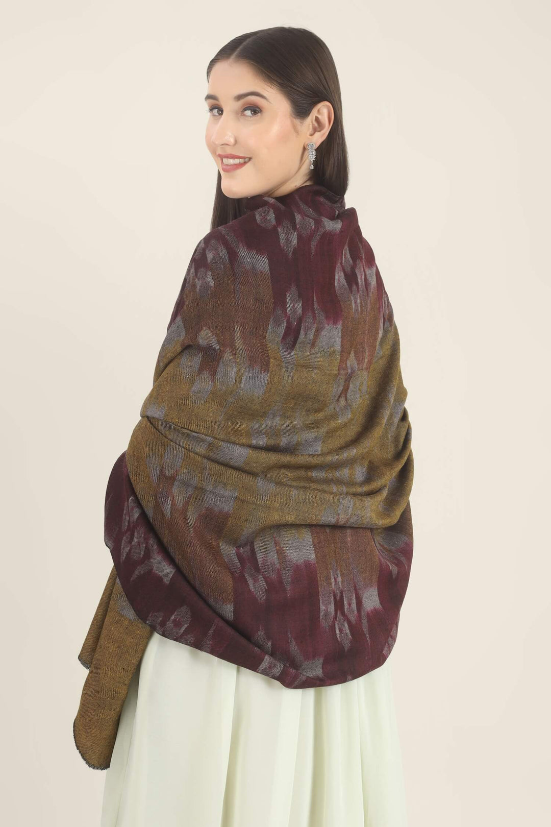 Model draped in a wine and mustard Pure Kashmiri Pashmina shawl with woven lilac-grey floral motifs over a pale green embroidered dress.