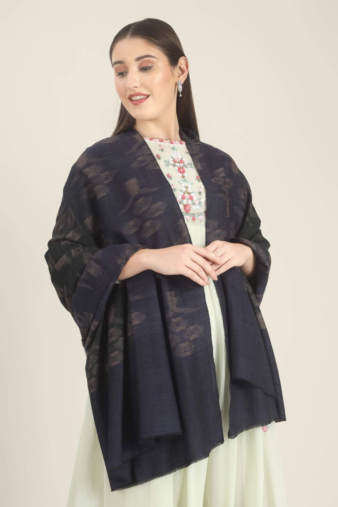 Model draped in a navy Pure Kashmiri Pashmina shawl with woven dusty mauve floral motifs over a pale green embroidered dress.
