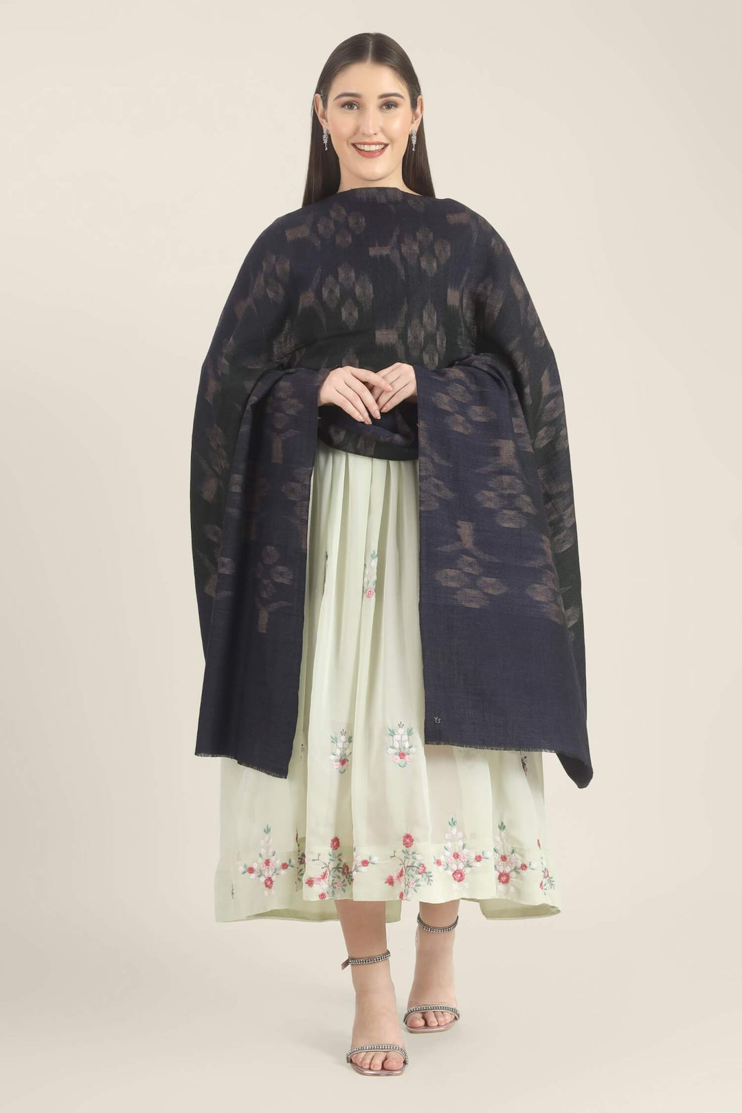 Model draped in a navy Pure Kashmiri Pashmina shawl with woven dusty mauve floral motifs over a pale green embroidered dress.