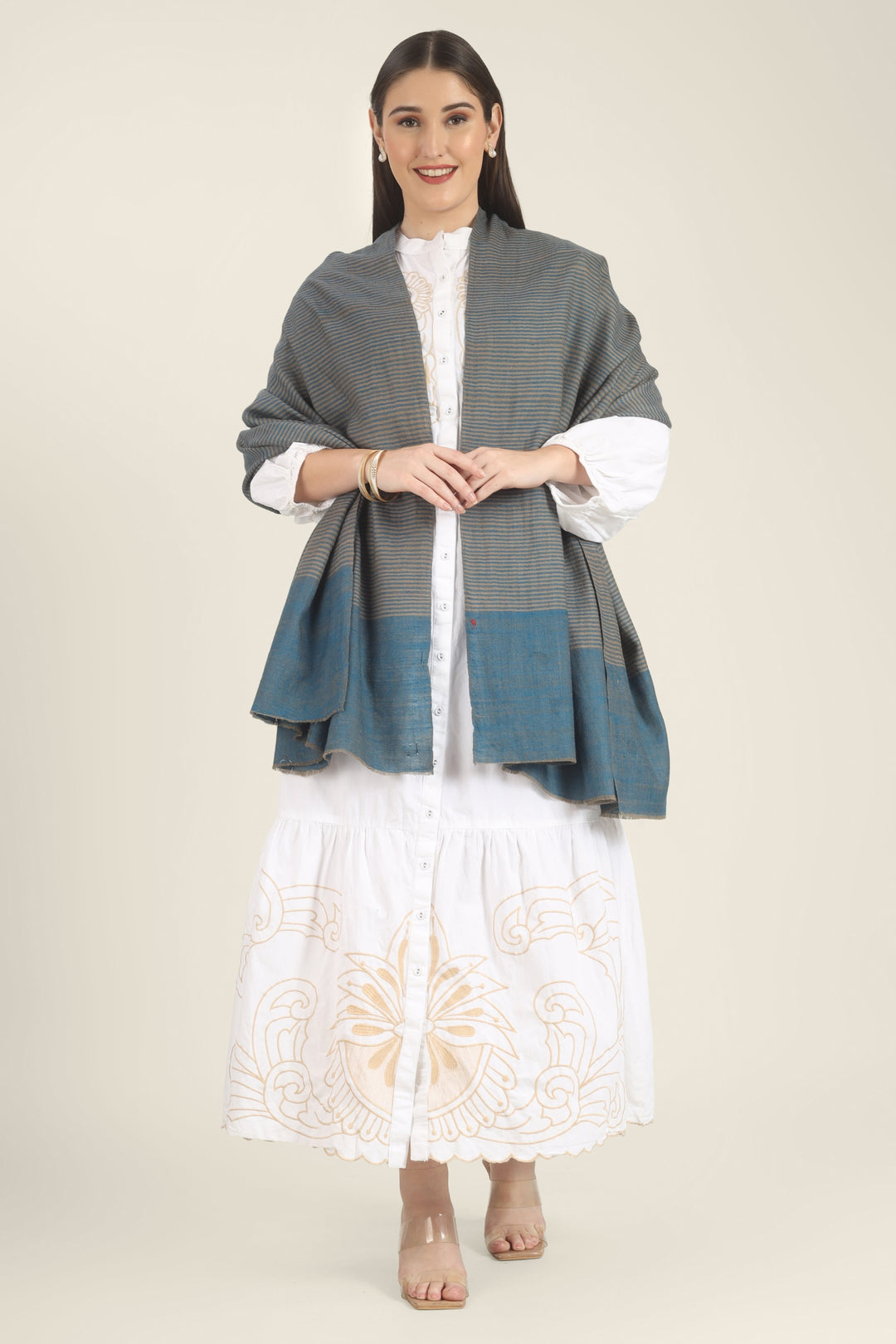 Model draped in a teal and taupe Pure Kashmiri Pashmina shawl with fine woven stripes and a wide plain teal border over a white embroidered dress.