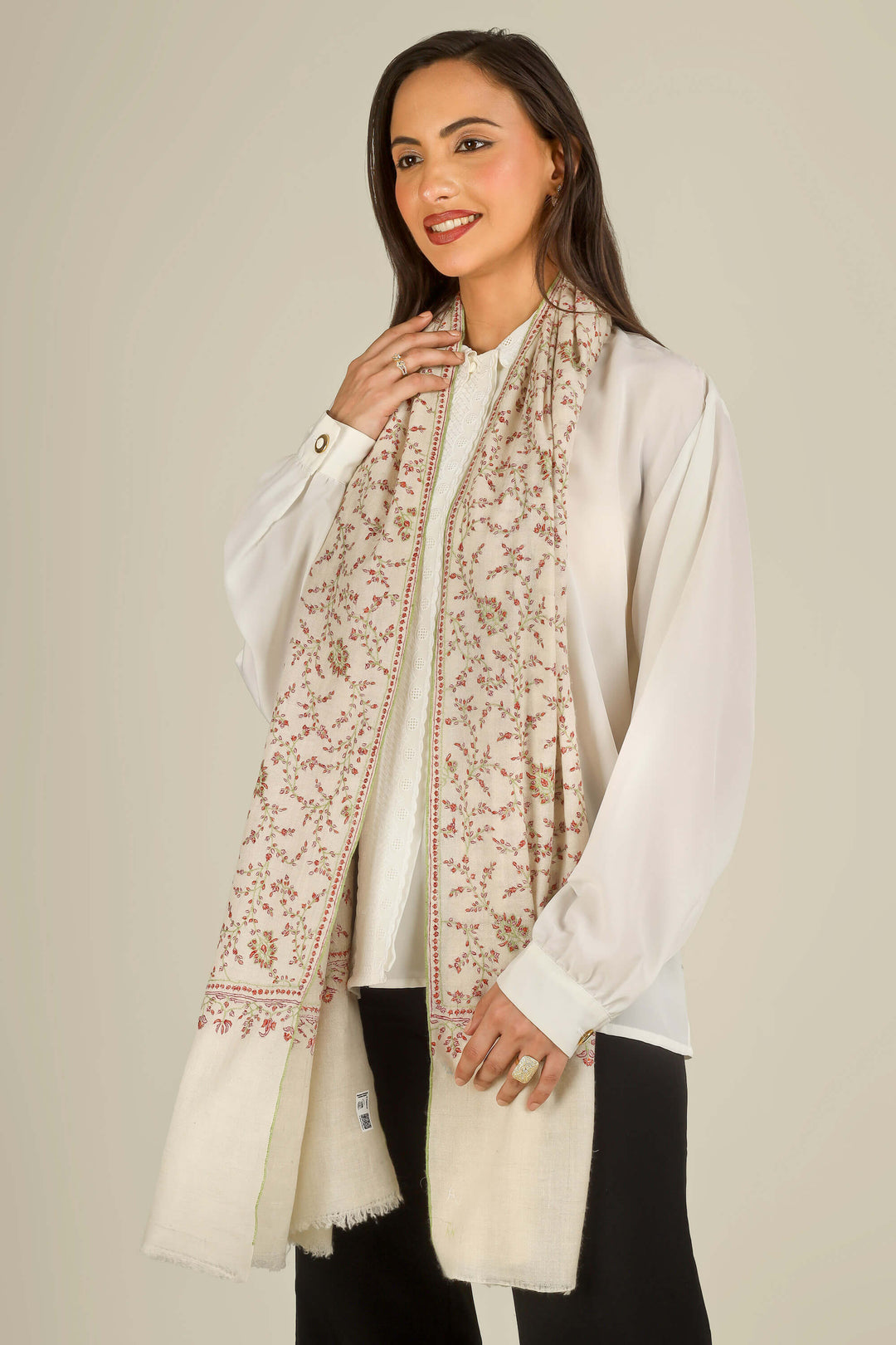 GI cream Kashmiri pure pashmina embroidered stole by Kepra, worn over white shirt and black trousers on smiling model, front view