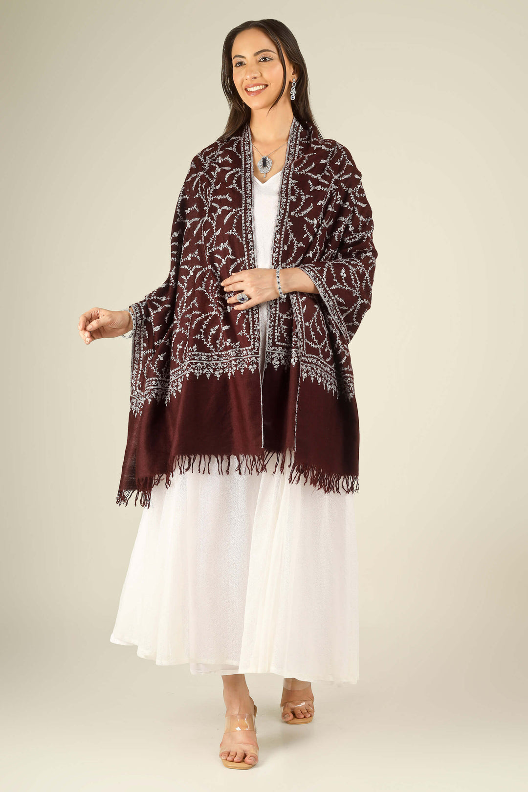GI maroon Kashmiri pure pashmina embroidered stole by Kepra, draped on smiling model in white dress, front view for Kolkata winter styling