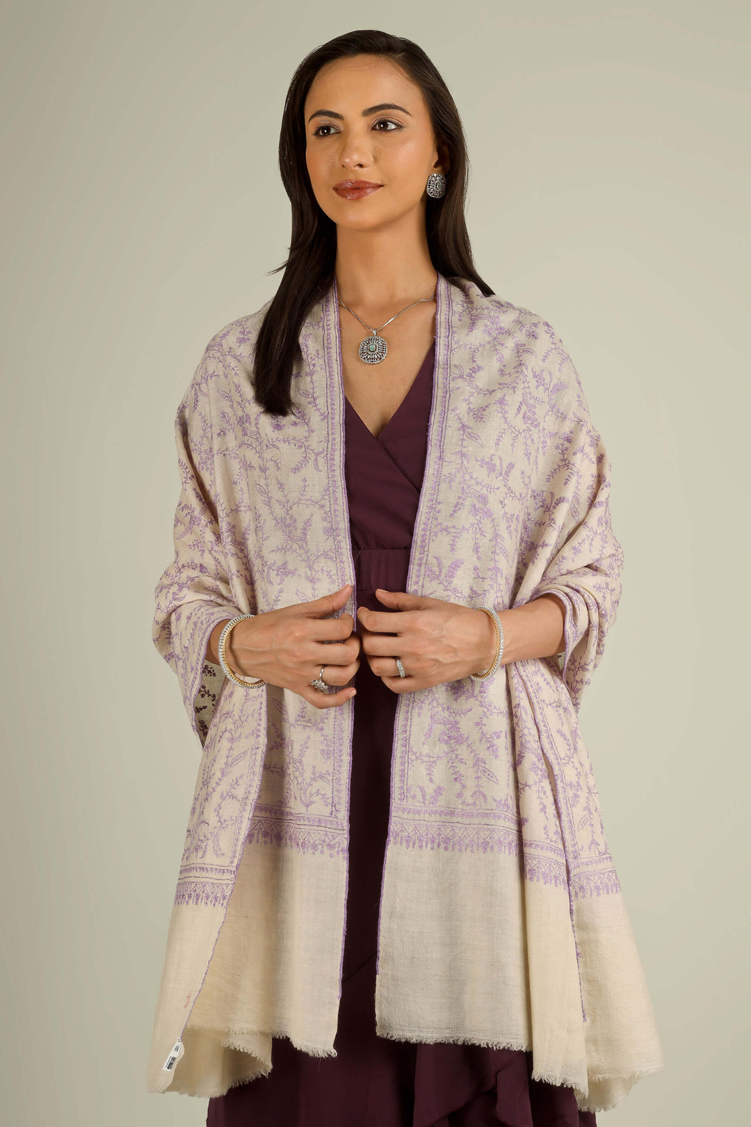 Ivory GI Kashmiri pure pashmina embroidered stole with lilac floral vines by Kepra, draped on model over plum dress, front view for Zurich winter styling