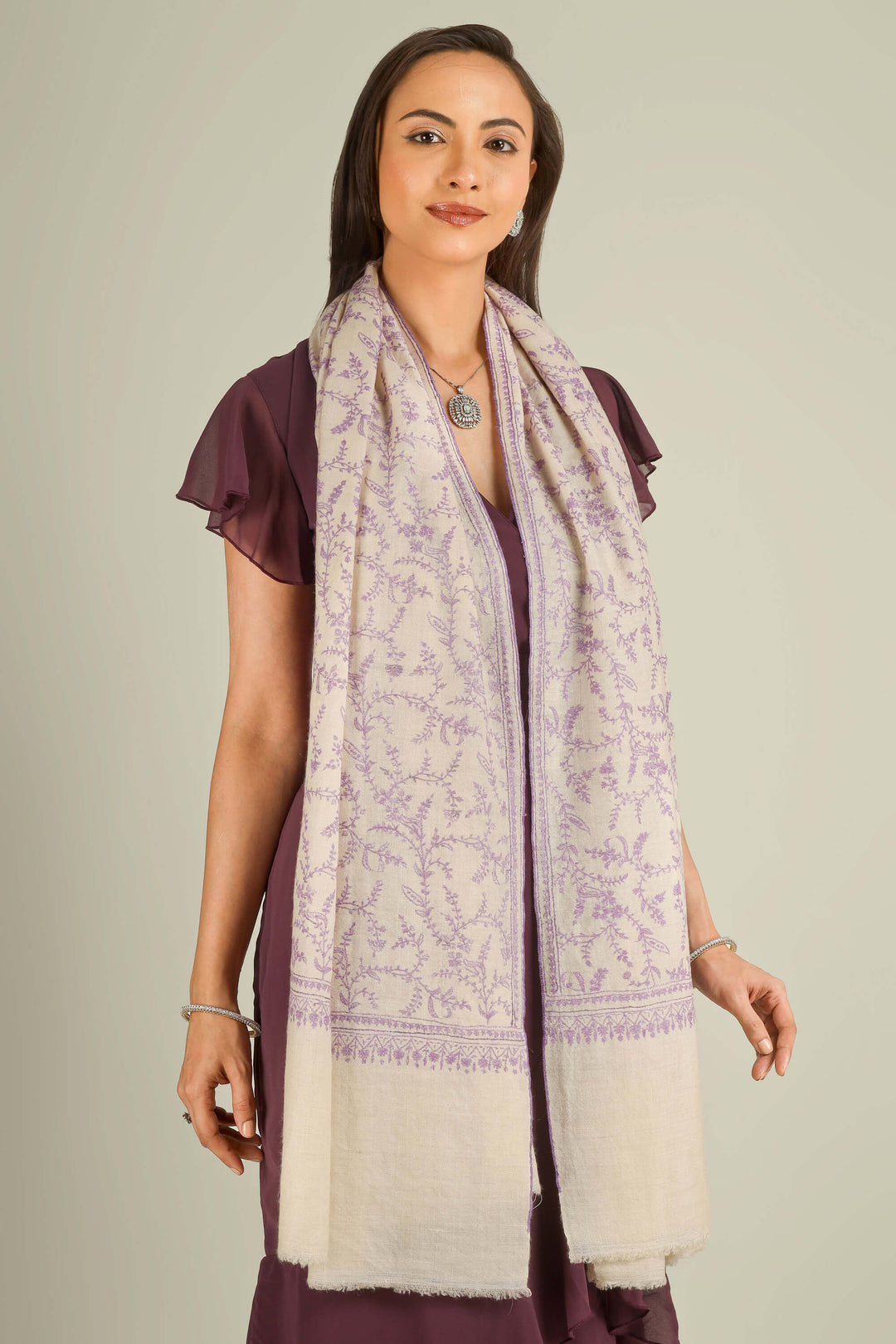Ivory GI Kashmiri pure pashmina embroidered stole with lilac floral vines by Kepra, draped on model over plum dress, front view for Zurich winter styling