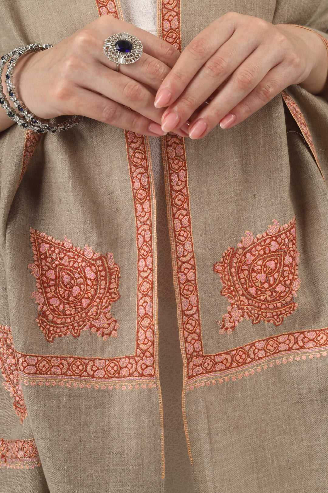 This Beige Pure Kashmiri Pashmina Paisley Embroidered Stole features a soft natural beige body decorated with richly worked paisley motifs and framed borders in rust, coral and pink.