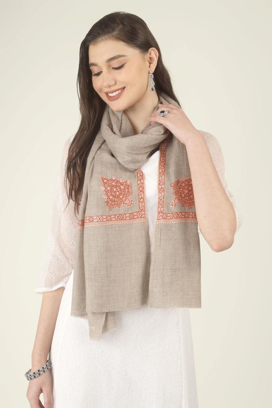 This Beige Pure Kashmiri Pashmina Paisley Embroidered Stole features a soft natural beige body decorated with richly worked paisley motifs and framed borders in rust, coral and pink.