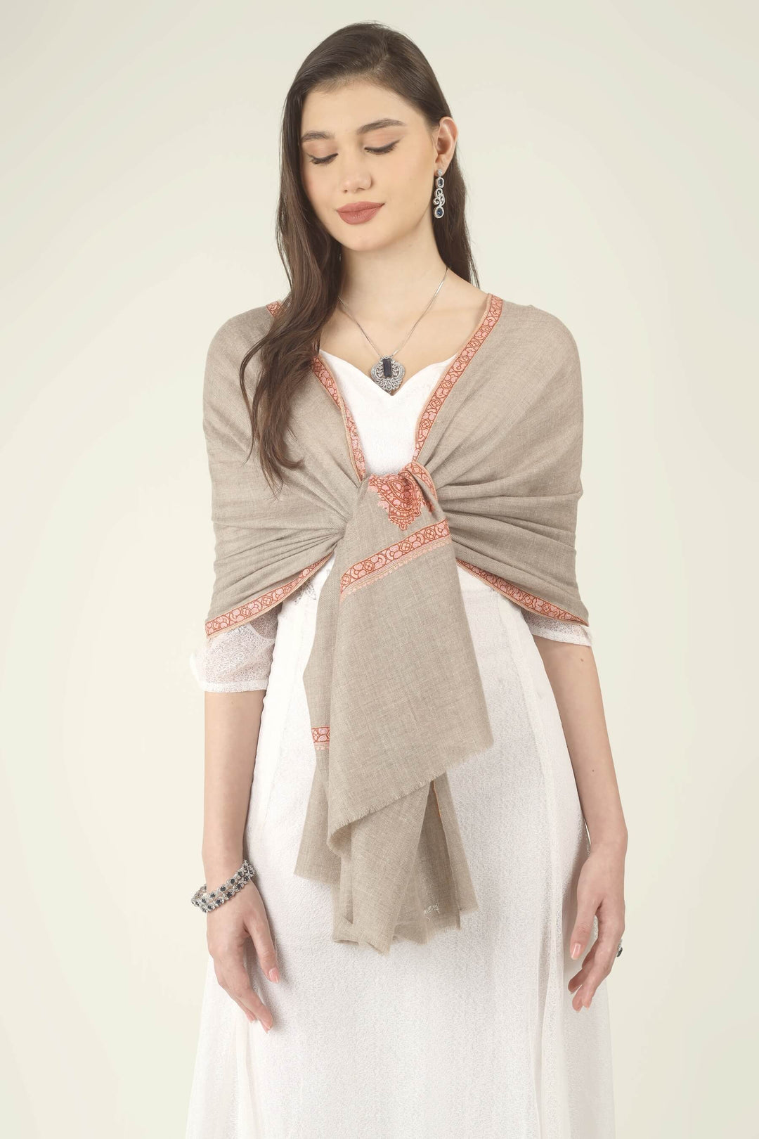 This Beige Pure Kashmiri Pashmina Paisley Embroidered Stole features a soft natural beige body decorated with richly worked paisley motifs and framed borders in rust, coral and pink.