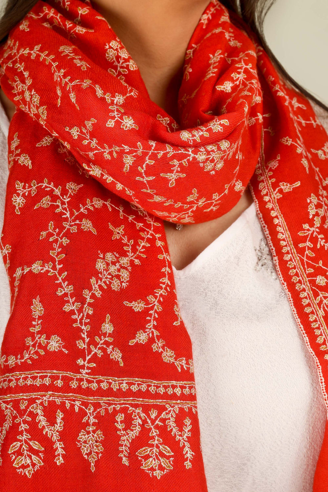 GI red Kashmiri pure pashmina embroidered stole by Kepra, draped on model in white dress, front view for Delhi winter styling