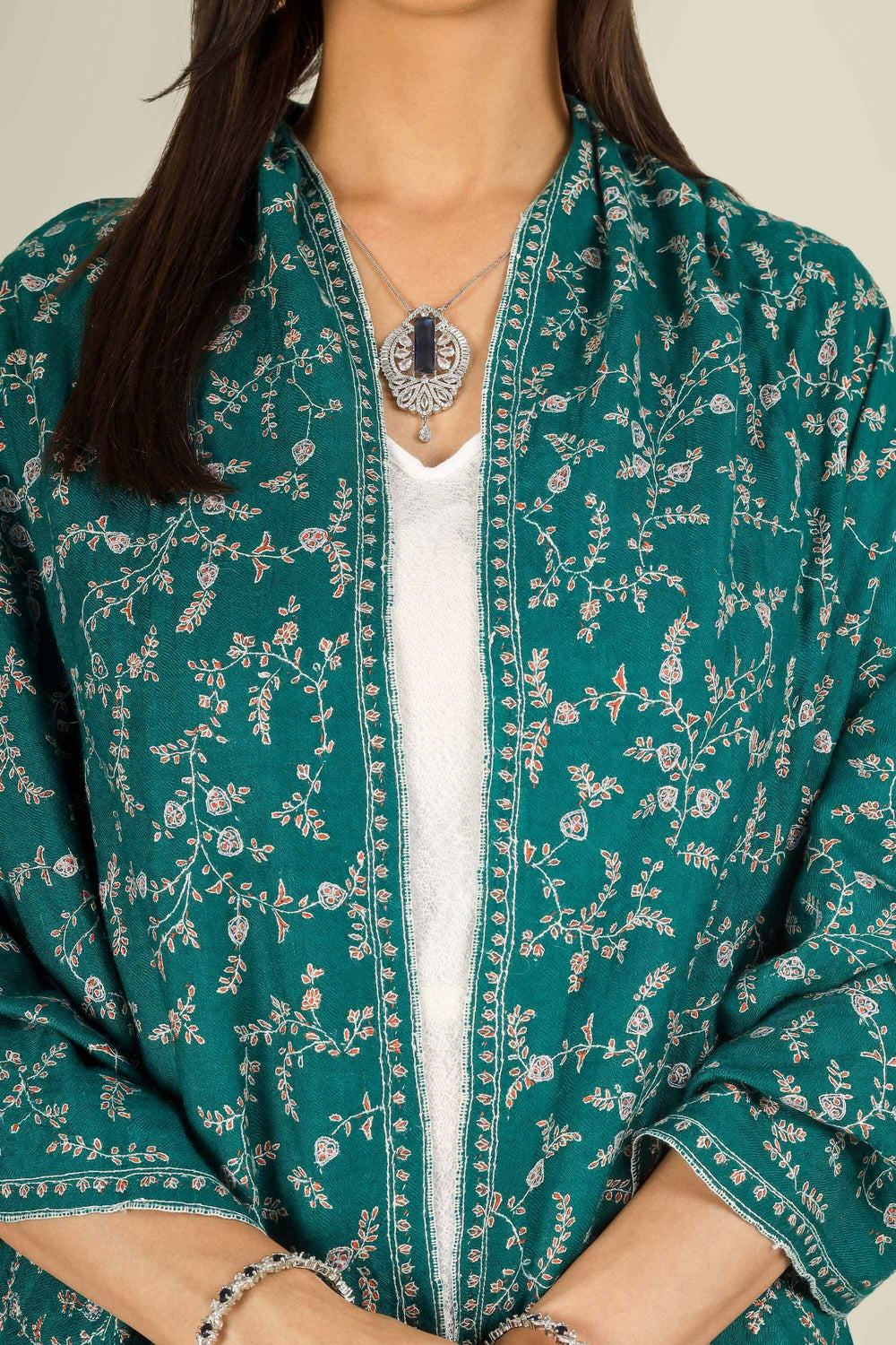 GI teal Kashmiri pure pashmina embroidered stole by Kepra, draped on smiling model in white dress, front view for Paris winter styling