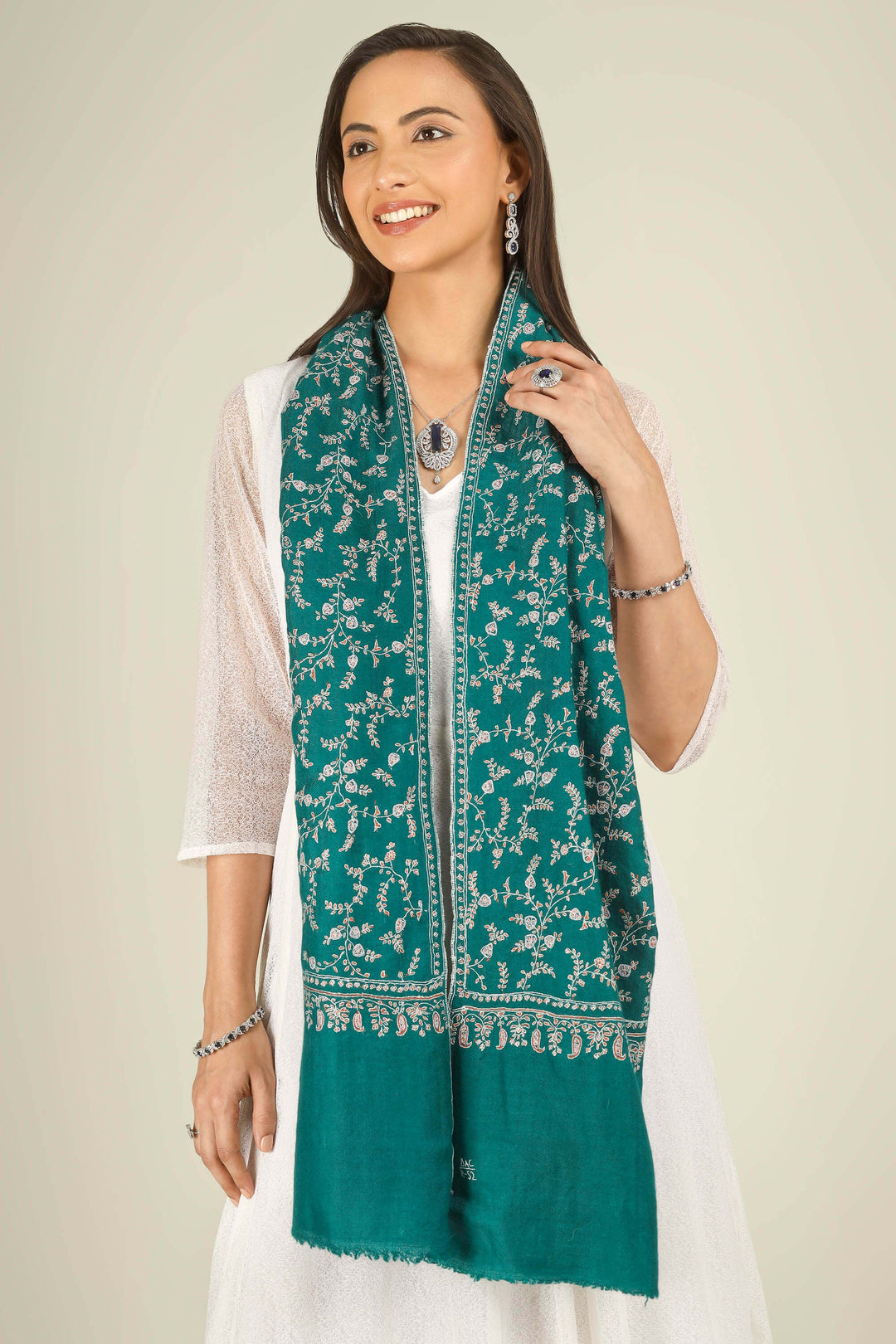 GI teal Kashmiri pure pashmina embroidered stole by Kepra, draped on smiling model in white dress, front view for Paris winter styling