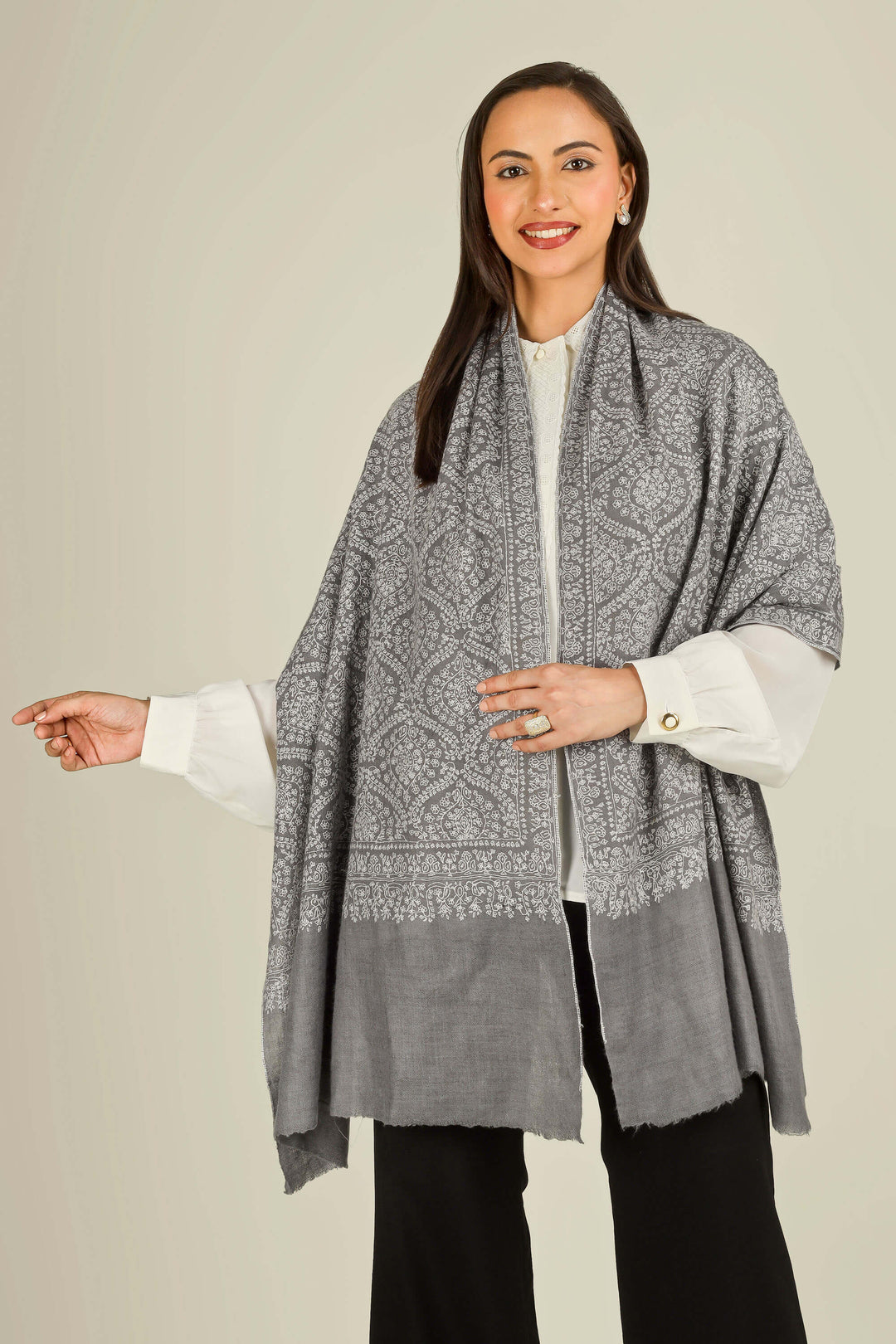 GI grey Kashmiri pure pashmina embroidered stole by Kepra, draped on smiling model over white shirt and black trousers, front view