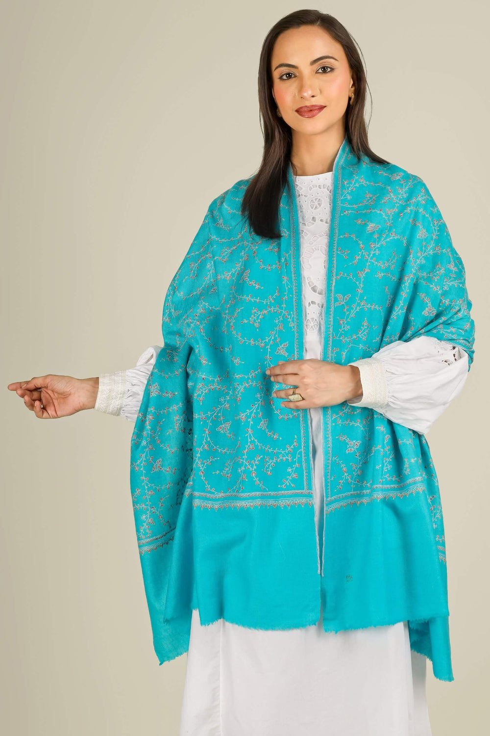 This GI Turquoise Kashmiri Pure Pashmina Embroidered Stole is a bright, refreshing accessory, handwoven in Kashmir and patterned with delicate all-over vines that frame the edges and flow softly along the length of the fabric.