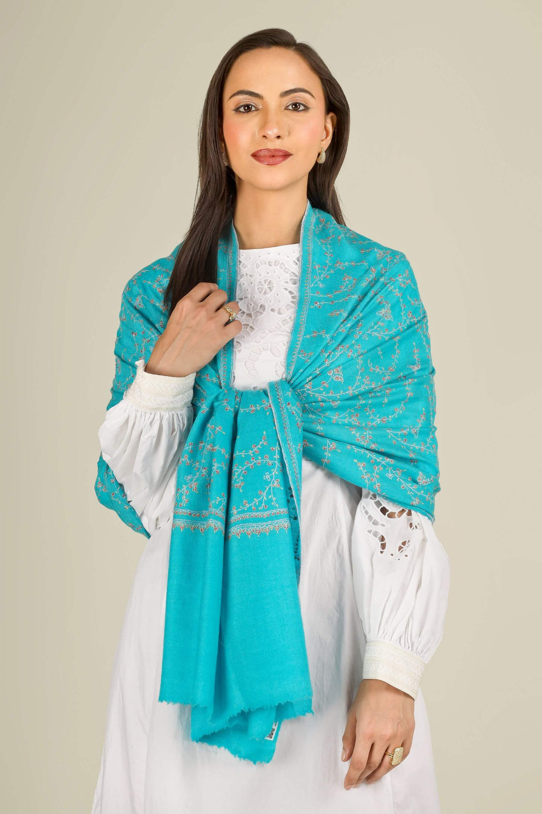 This GI Turquoise Kashmiri Pure Pashmina Embroidered Stole is a bright, refreshing accessory, handwoven in Kashmir and patterned with delicate all-over vines that frame the edges and flow softly along the length of the fabric.