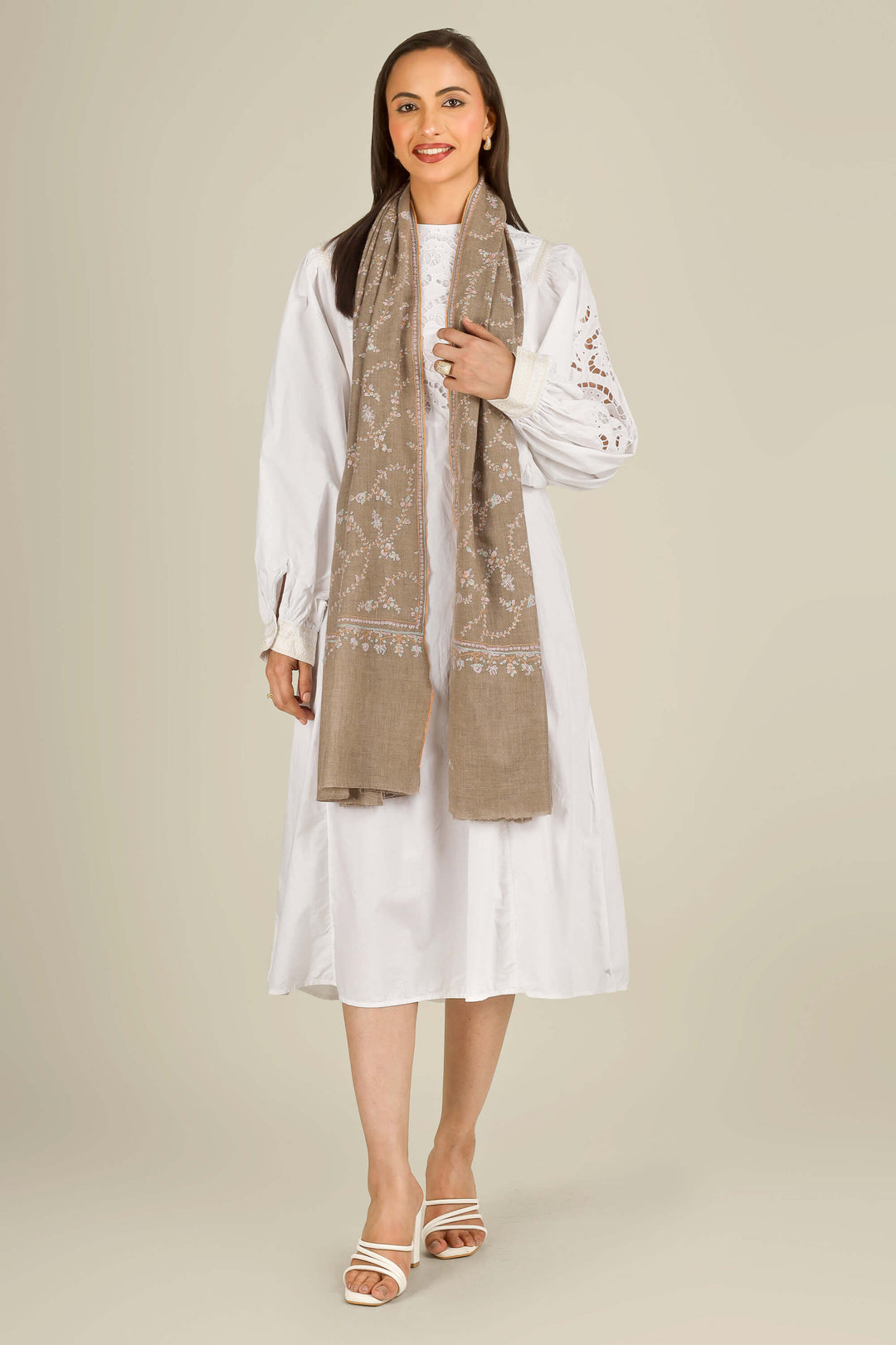 GI taupe Kashmiri pure pashmina embroidered stole by Kepra, draped over white dress on smiling model, front view