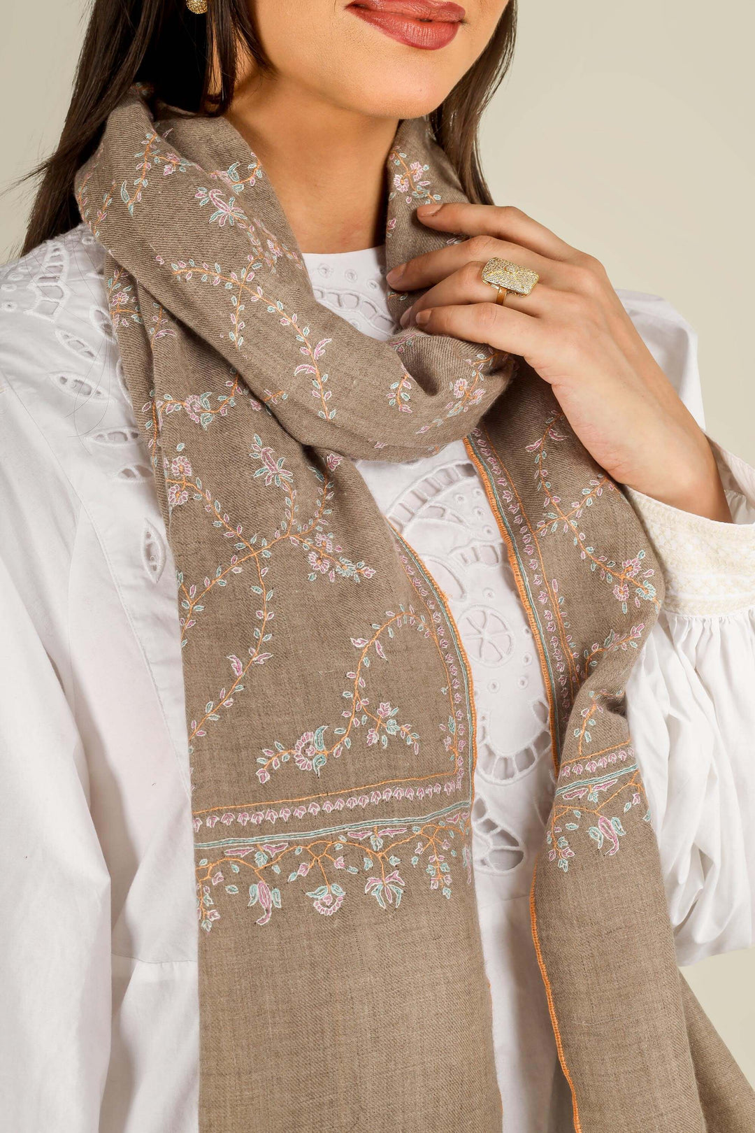 GI taupe Kashmiri pure pashmina embroidered stole by Kepra, draped over white dress on smiling model, front view