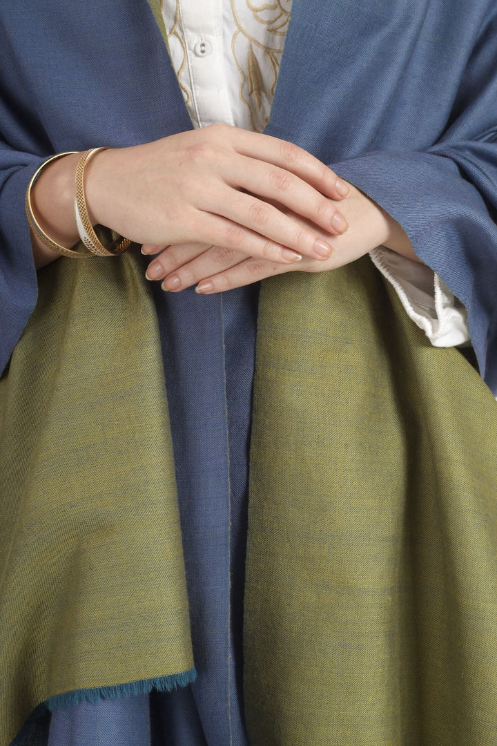 Model wearing a blue and olive-green reversible Pure Kashmiri Pashmina shawl with teal fringe over a white embroidered dress.
    
      | pashmina shawls online | authentic Kashmiri pashmina shawl online | pure pashmina shawl online | original GI certified pashmina shawl online | luxury men's pashmina shawl online from Kashmir | where to buy online pure pashmina in India
    
    | GI Tag Certified - Government-verified authentic Kashmiri Pashmina
    | G20 Official Partner - Selected by India for G20 Summit gifting
    | Handicraft Registered - Official recognition of traditional craftsmanship
    | Certificate of Authenticity - Every purchase includes GI certification