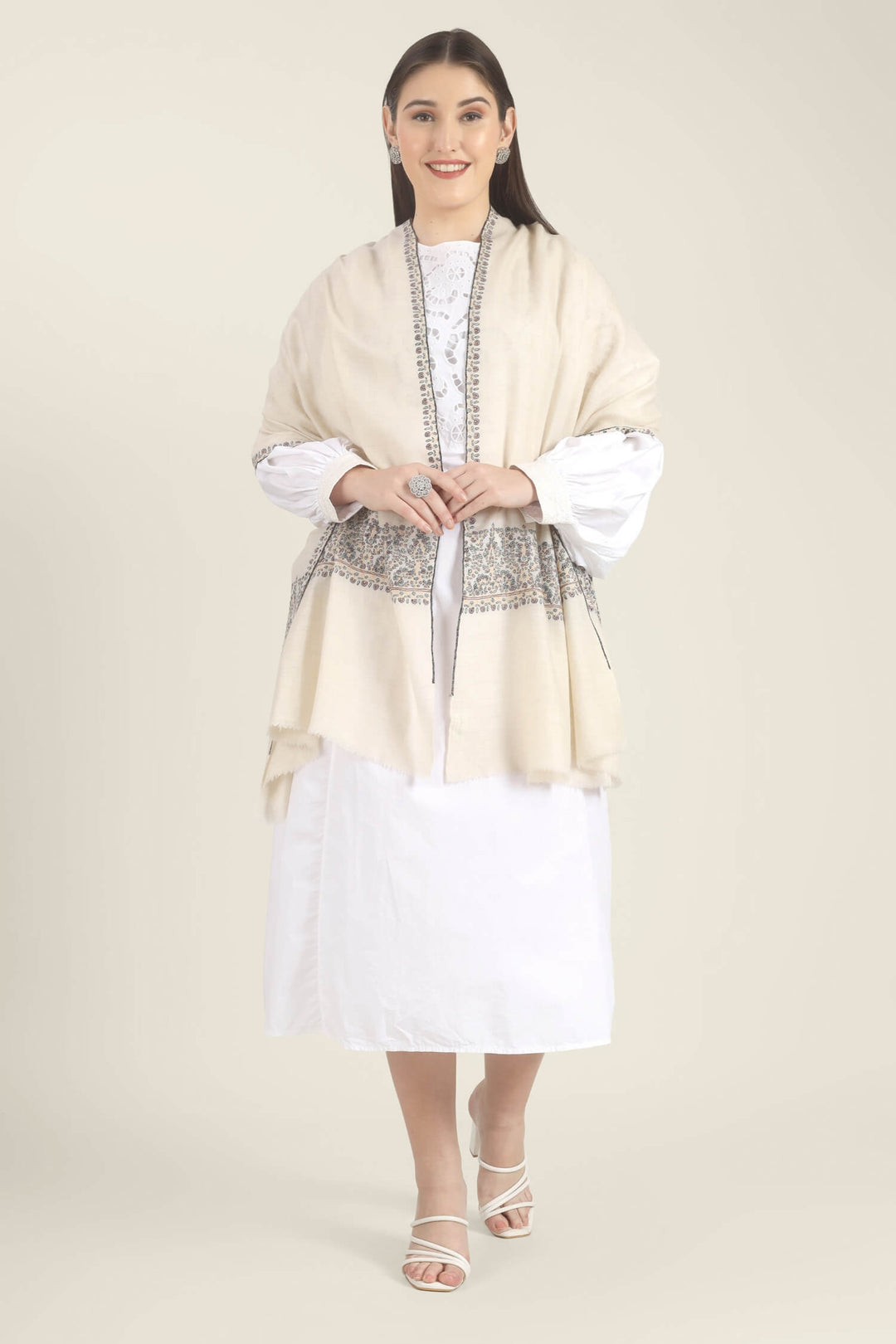 Model wearing a white GI Kashmiri Pure Pashmina stole with multicolour floral Sozni embroidered borders over a white outfit.
