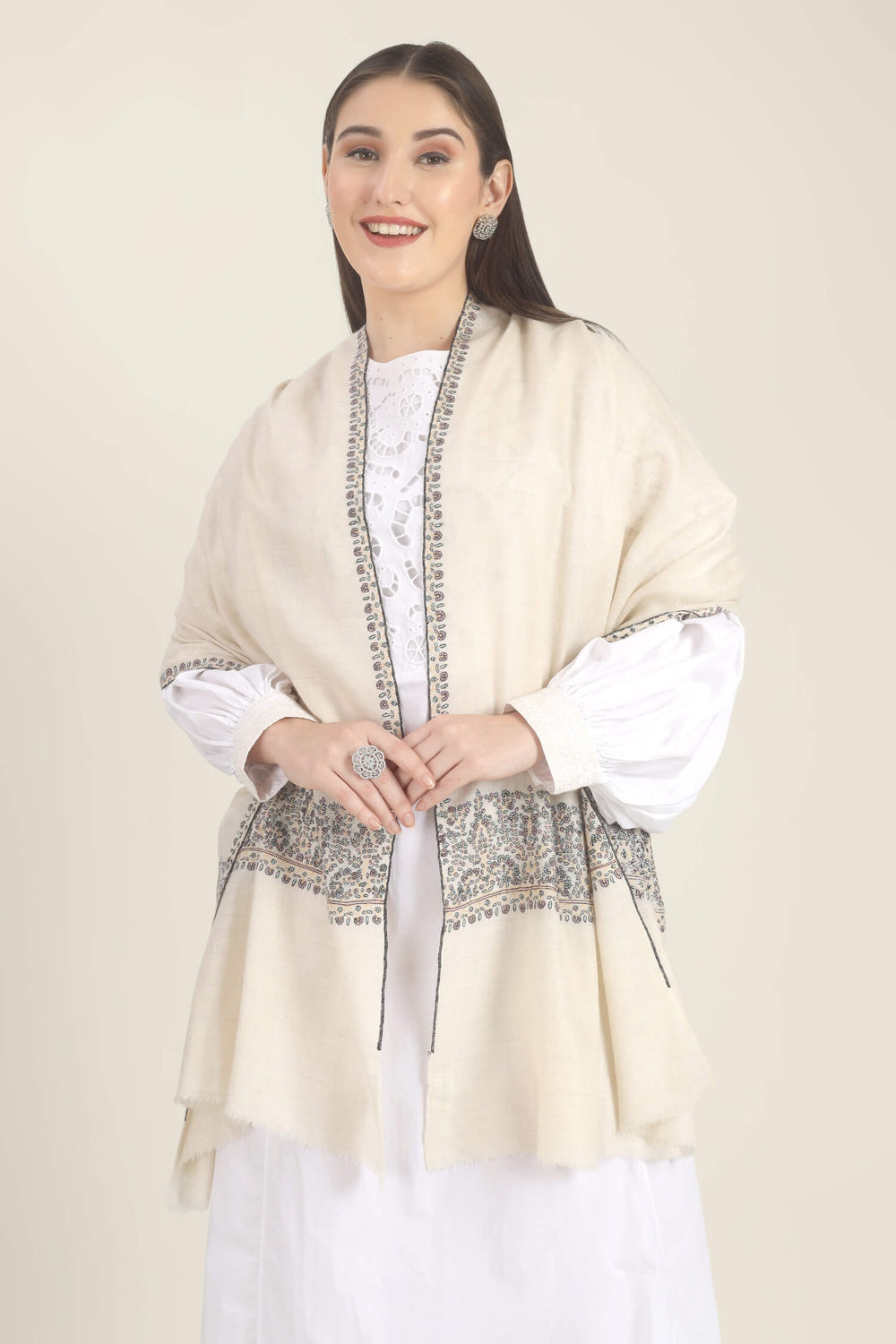Model wearing a white GI Kashmiri Pure Pashmina stole with multicolour floral Sozni embroidered borders over a white outfit.